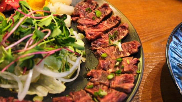 Freshly prepared vegetables and beef tataki on a plate