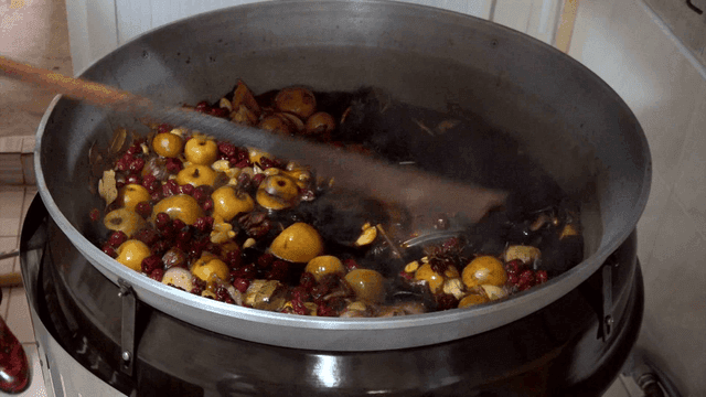 A large pot of fruit and spices boiling