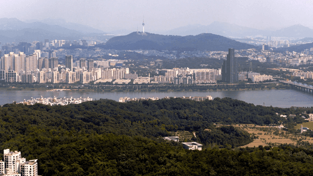 A city skyline with a river and mountains