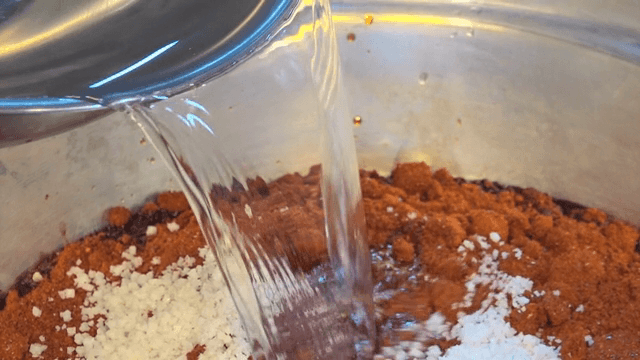 다양한 재료가 있는 냄비에 물을 붓는 장면