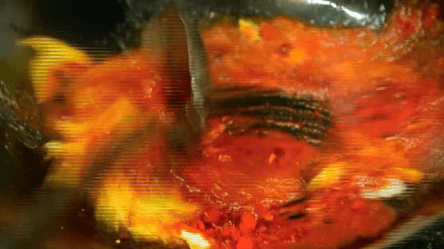 뜨거운 웍에서 채소와 고춧가루를 볶는 모습