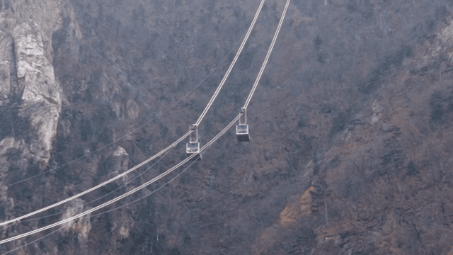Cable cars moving through a mountain landscape