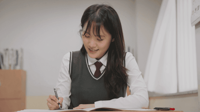 시험 문제를 풀며 웃는 학생