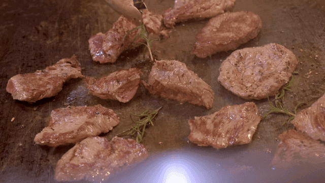 Meat grilled with herbs on hot iron plate