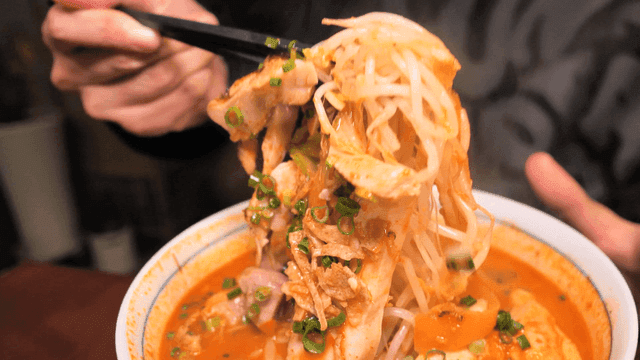 Spicy chicken rice noodles eaten with chopsticks