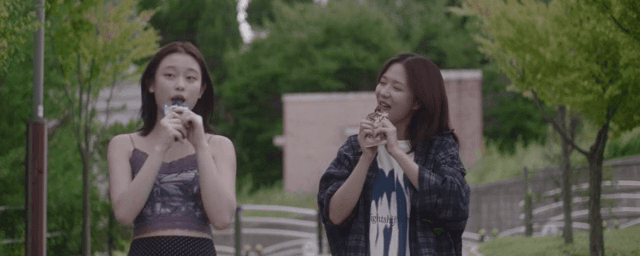 Two friends walking while eating ice cream