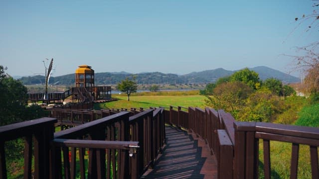 맑은 날 전망탑이 있는 경치 좋은 공원의 목조 산책로