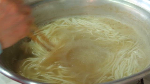 Noodle soup boiling in a pot