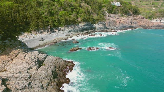 청록빛 파도가 치는 바위 해안선