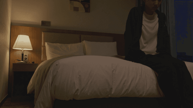 어두운 방에서 침대에 눕는 여자