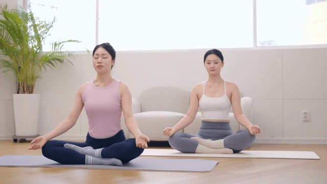 밝은 방에서 명상하는 두 여성