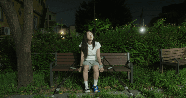 Woman with crutches sitting on a bench