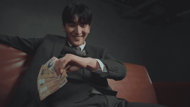 소파에 앉아 돈을 뿌리는 남성