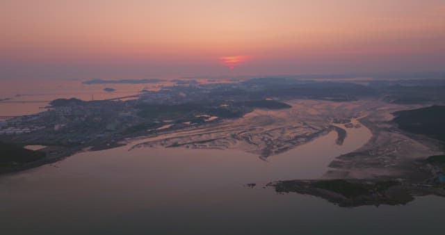 Sunset over a calm sea with distant mountain