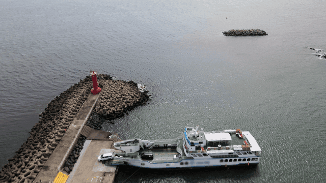 Vehicles coming out of ferry docked at coastal pier