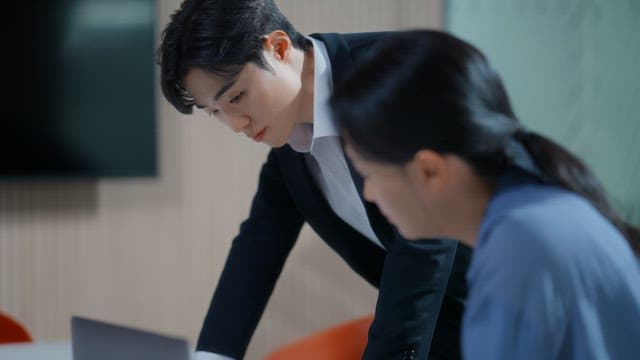 Two colleagues discussing work at a desk