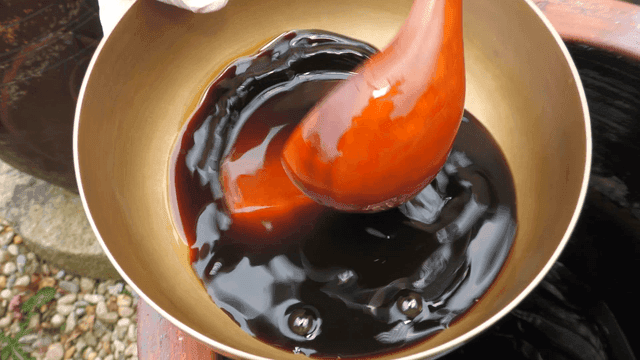 항아리에서 간장을 그릇에 담는 모습