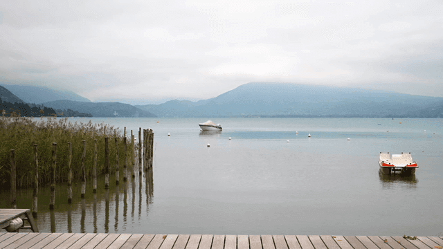 A tranquil lake with boats and mountains