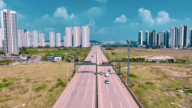 Highway leading to city with high-rise buildings