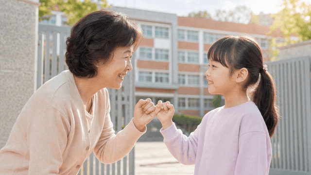 Grandmother and granddaughter making promise in front of school
