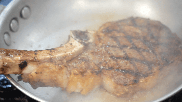 Steak being seared in a hot pan