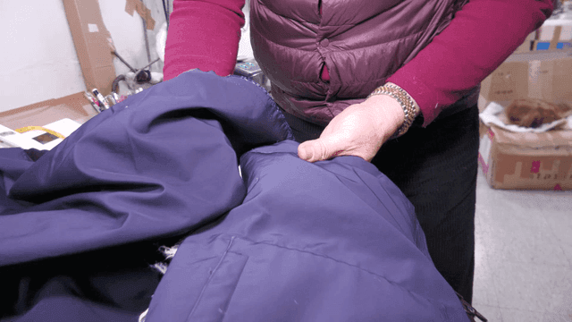 파란 자켓 천을 살펴보는 사람