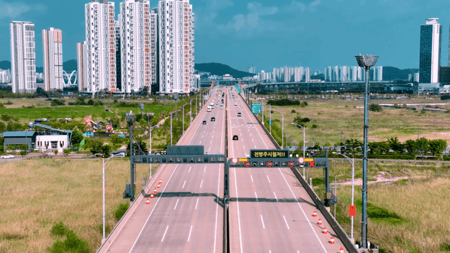 Highway leading to city with high-rise buildings