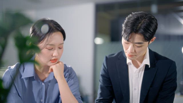 Two colleagues discussing documents