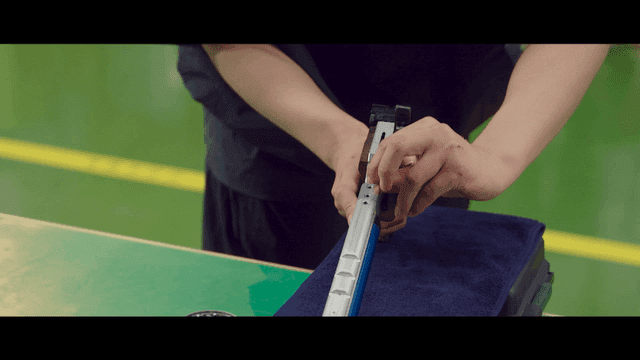 Person adjusting sports shooting gun on table