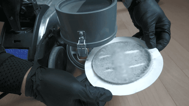 Hands removing vacuum cleaner's dust-filled filter