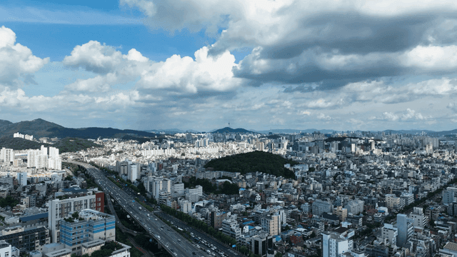 Panoramic view of city spread out under cloudy sky