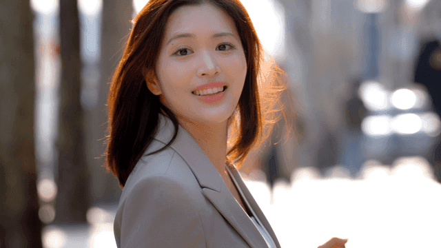 Female office worker smiling while looking back while walking outdoors