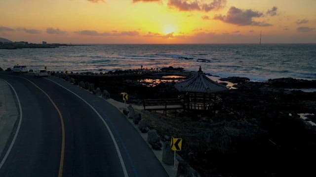 일몰 시간 해변의 도로와 거친 파도가 있는 바다