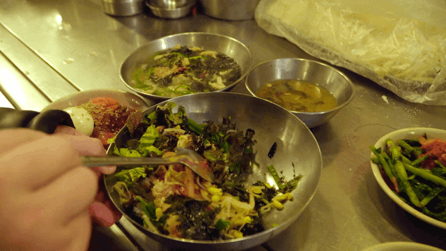 Mixing bibimbap with various side dishes