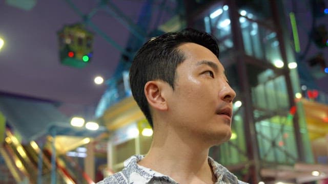 Man at an amusement park at night