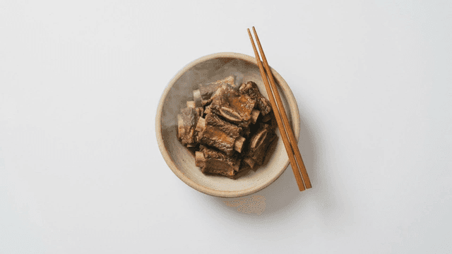 Steaming bowl of braised pork ribs