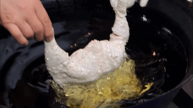 생닭을 반죽에 묻혀 기름에 튀기는 장면