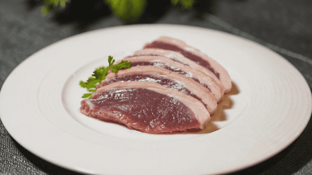 Slices of raw duck breast on a plate
