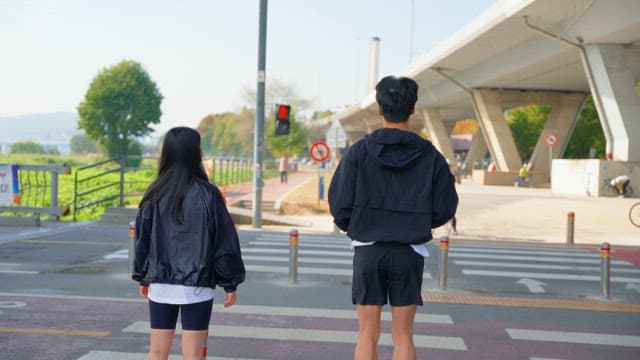 횡단보도에서 기다리며 준비운동을 하는 사람들