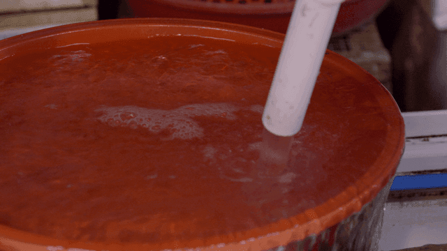 Red basin into which water is poured