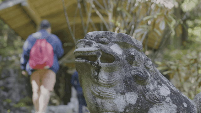 People walking in garden and Japanese stone statues