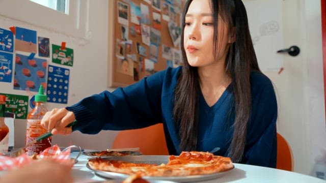 Young woman enjoying pizza indoors