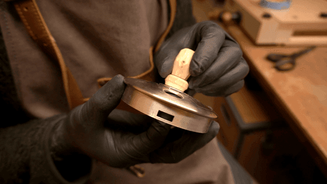 장인이 나무 조각과 금속 부품을 조립하는 모습