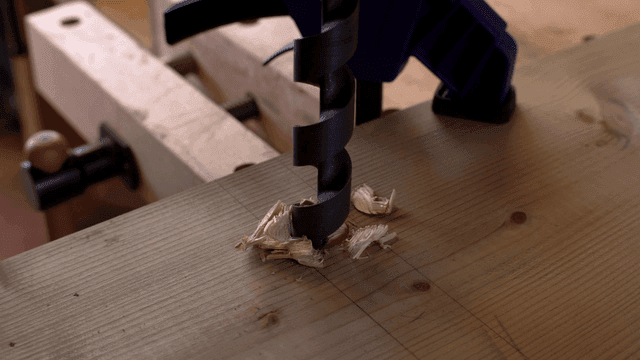 공구로 나무를 뚫는 장면