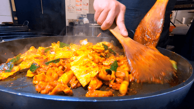 주걱으로 볶아지는 철판 닭갈비