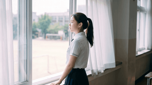 교실 창문 밖을 바라보는 여학생