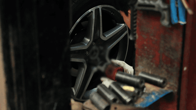 Mechanic working on a car tire in garage