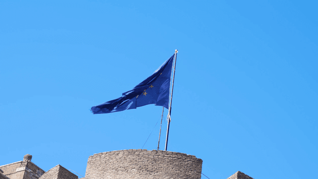 European Union flag fluttering over historic building