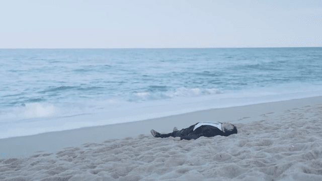 바닷가 모래사장에 누워 있는 사람