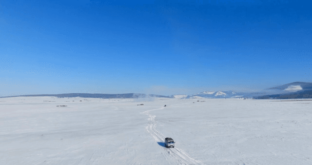 Vehicle traveling across a snowy landscape